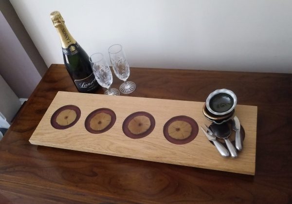 Oak Charcuterie Board with Ash and Purple Resin dressed with ceramic bowls, champagne and glasses