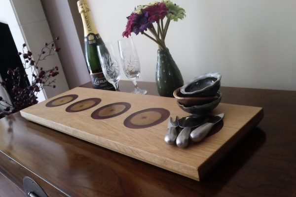 Oak Charcuterie Board with Ash and Purple Resin dressed with flowers, ceramic bowls, champagne and glasses