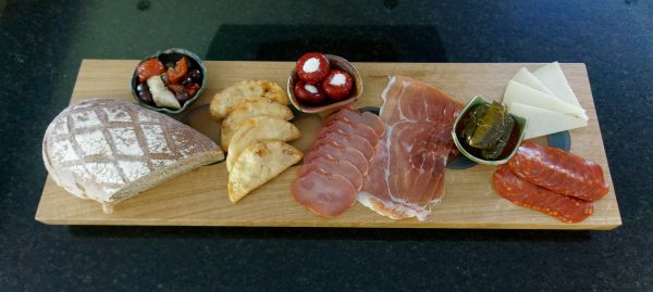 Oak Charcuterie Board with selection of cold meets and side dishes