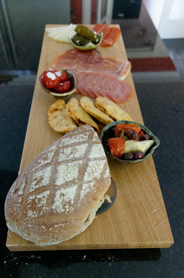Oak Charcuterie Board with selection of cold meets and side dishes