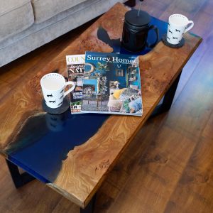 Burr elm and blue resin coffee table dressed with magazines and coffee cups