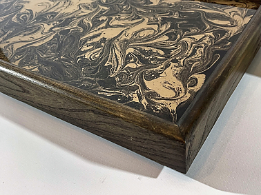 Corner detail of ebonised elm ottoman tray with black and gold resin