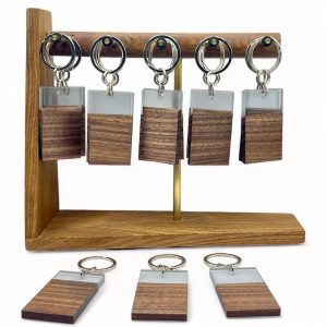 Walnut and resin keyrings hung on a display stand with three separate items in foreground