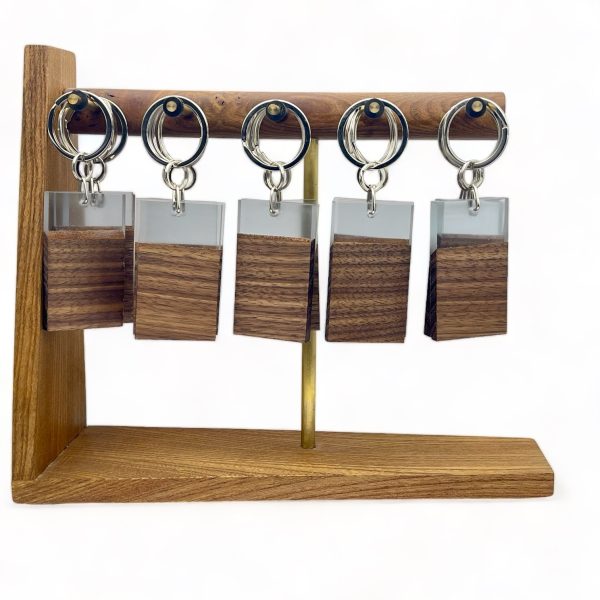 Walnut and resin keyrings hung on a display stand.